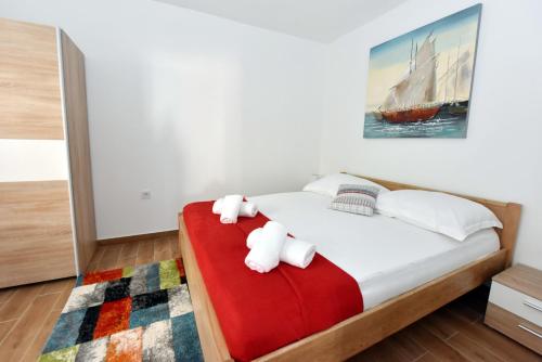 a bedroom with a bed with two stuffed animals on it at Apartman MiR in Šibenik
