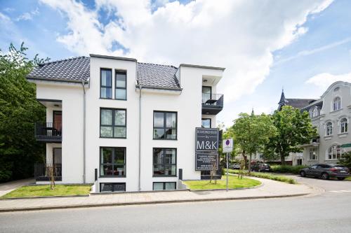 a white building with a sign in front of it at Boardinghouse by M&K in Bad Oeynhausen