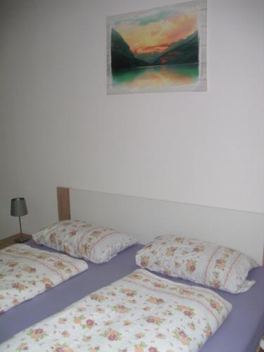 Gästewohnung in Döbeln في دوبلن: سريرين في غرفة نوم مع لوحة على الحائط