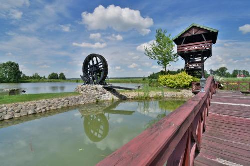 a watermill and a wooden bridge with a pond at Domek nad stawem in Działdowo