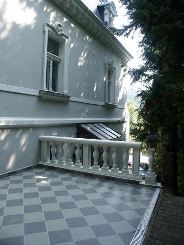 a white house with a balcony and a window at Edinburgh in Mariánské Lázně