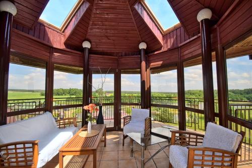 a screened in porch with a couch and chairs at Domek nad stawem in Działdowo