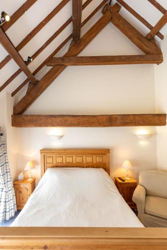 a bedroom with a large bed and a chair at Church Farm Lodge in Harrington