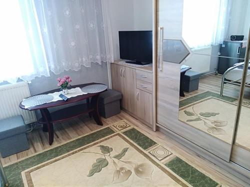 a living room with a tv and a table and a room at Ubytovanie u Vlasty in Štrba