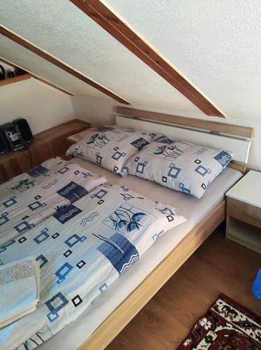 a bed with two pillows on it in a room at Ubytovanie u Vlasty in Štrba