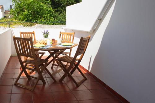 a table and four chairs on a balcony with a table at Just Like Home in Ponta Delgada