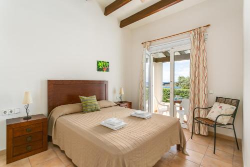 a bedroom with a bed and a chair and a window at Villa BiniLlor by Mauter Villas in Binissafuller