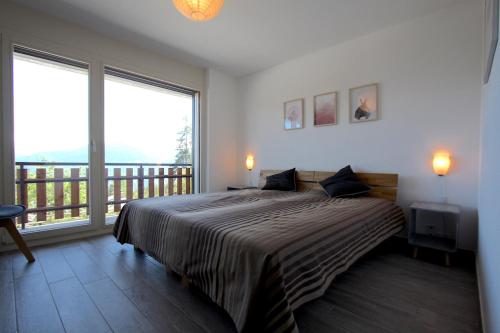a bedroom with a large bed and a balcony at Apartment Weisshorn in Crans-Montana
