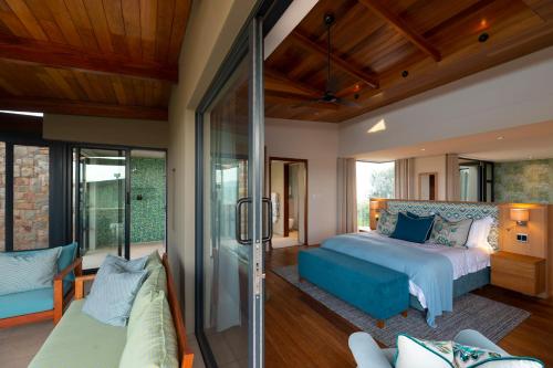 a bedroom with a bed and a living room at Alkira Lodge in Brenton-on-Sea