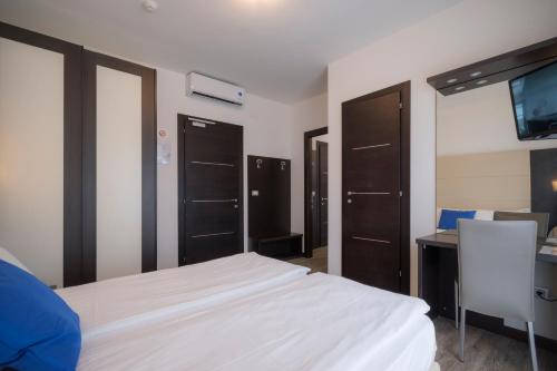 a bedroom with a bed and a desk and a tv at Hotel Bristol in Caorle
