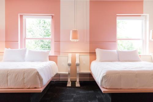 two beds in a room with two windows at The Russell in Nashville