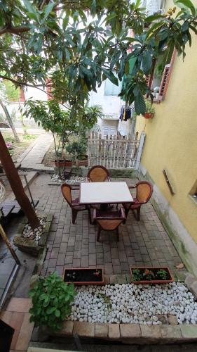 a patio with a table and chairs under a tree at Apartmaji Mila Piran in Piran