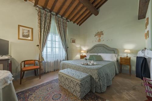 una camera da letto con un letto, una sedia e un tavolo di Villa De' Michelangioli a Castroncello