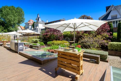 a patio with a table and an umbrella and a pool at Santemar in Santander