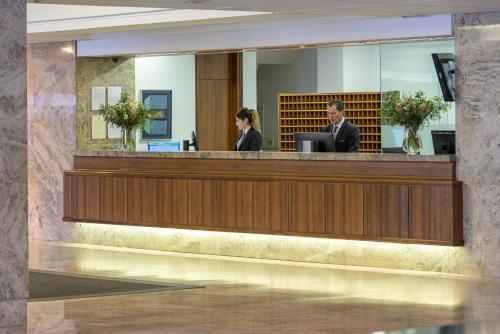 a man and a woman sitting at a reception desk at Santemar in Santander