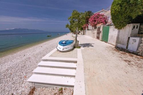 a boat parked on a beach next to the water at Apartments Natalika in Podaca