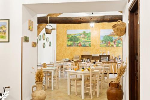 a dining room with white tables and chairs at Case Di Latomie in Castelvetrano Selinunte