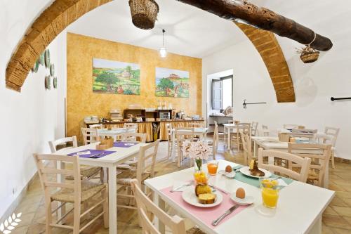 a dining room with tables and chairs and a kitchen at Case Di Latomie in Castelvetrano Selinunte