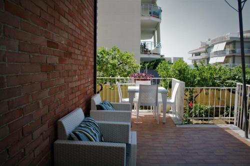 a patio with chairs and tables and a brick wall at Sogno Mediterraneo in Formia