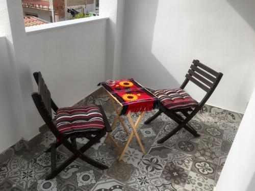 two chairs sitting next to a table with a colorful table cloth at ViNALUX in Vinaròs