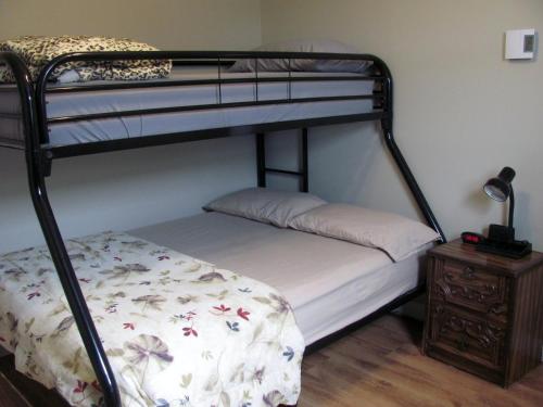 a bedroom with two bunk beds and a night stand at HI-Bonavista Hostel in Bonavista