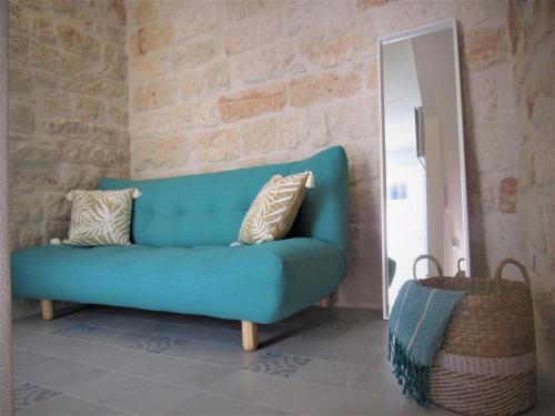 a blue couch in a room with a mirror at Nisea in Polignano a Mare
