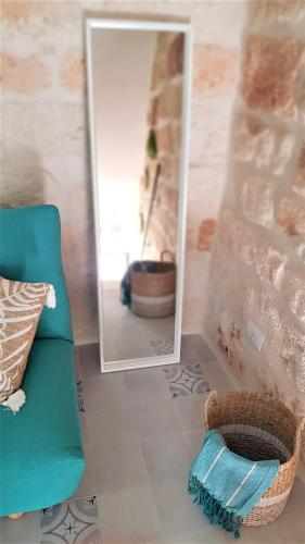 a mirror and a chair and a basket in a room at Nisea in Polignano a Mare