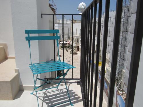 a blue chair sitting on a balcony next to a window at Nisea in Polignano a Mare