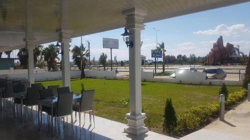 a table and chairs under a pavilion with a park at OLYMPIC HOTELS Belek in Belek