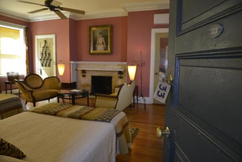 ワシントンにあるHotel Tabard Innのピンクの壁と暖炉とベッドのある寝室