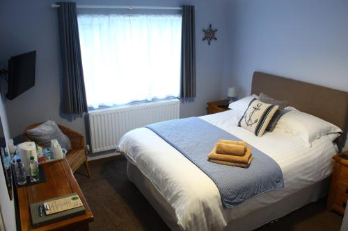 Un dormitorio con una cama con dos toallas encima. en Pinewood B&B, en Saundersfoot
