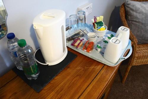 - Cafetera en una mesa con bebidas y botellas de agua en Pinewood B&B, en Saundersfoot