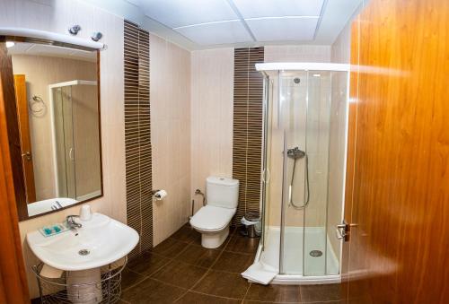 a bathroom with a shower and a toilet and a sink at Hotel Villa De Cárcar in Cárcar