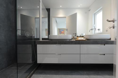 dois lavatórios numa casa de banho com armários brancos em Estrela Luxury Apartment em Lisboa