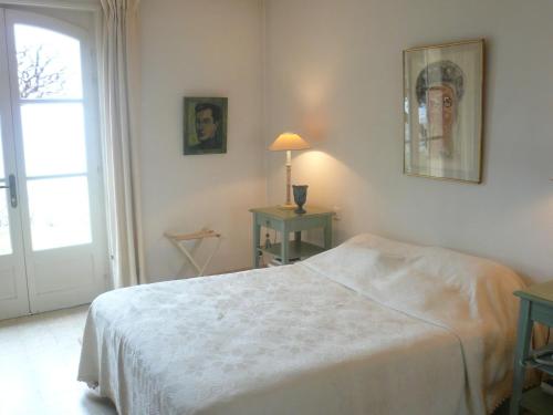 a white bedroom with a bed and a window at Charming country house with panoramic views in Séguret