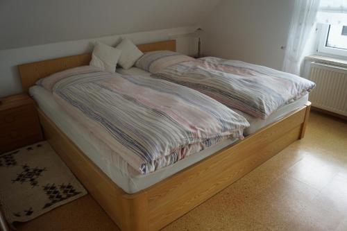 a bed with a wooden frame in a bedroom at Ferienwohnung Duß in Niederalteich