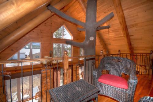 una habitación con una silla en una cabaña en Le Chalet Bois Rond Relax, en Saint-Tite-des-Caps