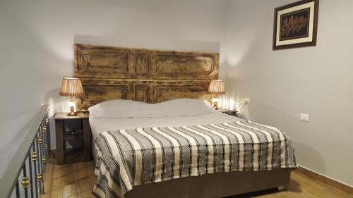Azur Suites Hotel & Apartments في El Mîna: غرفة نوم بسرير كبير مع اللوح الخشبي