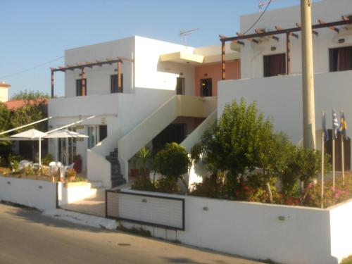 a white building with stairs and plants in front of it at Iliaktida Apartments in Kolymvari