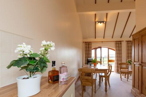 a kitchen with a table and a vase with flowers on a counter at Church Farm Lodge in Harrington