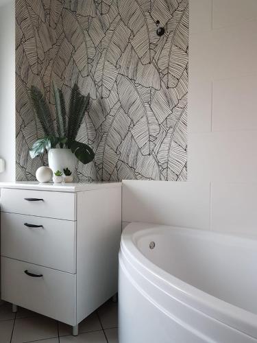 a bathroom with a toilet and a plant on a cabinet at Hotel Gold in Poznań
