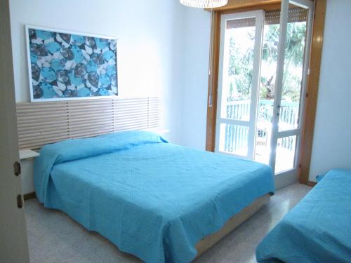 a bedroom with two beds and a window at Appartamento Pineta in Grado