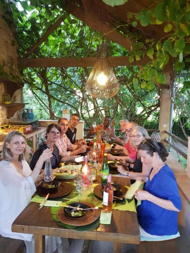 a group of people sitting around a wooden table at Le Clos d'Any in Fontet