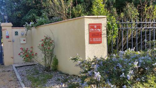 a wall with a sign on it next to some flowers at Le Clos d'Any in Fontet