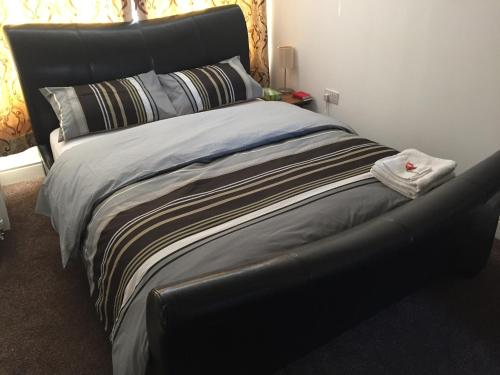 a large bed with a black headboard in a room at Alphalink Lodge in Middlesbrough
