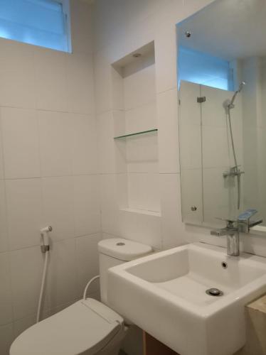 a white bathroom with a toilet and a sink at RedDoorz near Universitas Islam Indonesia in Yogyakarta