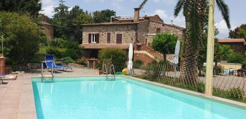 a swimming pool in front of a house at Borgo al Cielo - Albergo Diffuso in Suvereto