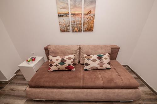 a couch with two pillows in a living room at Blue Sea in Herceg-Novi