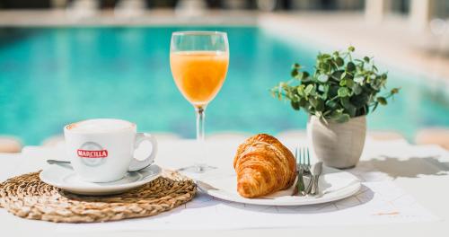 ein Tisch mit einem Glas Orangensaft und einem Teller Croissants in der Unterkunft Hotel Safari in Gandía