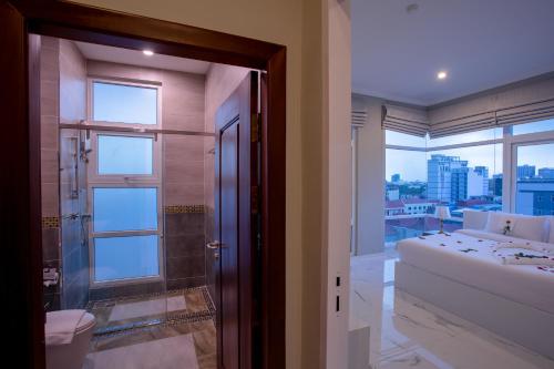 a bathroom with a shower and a bed and a window at SSB Residence in Phnom Penh